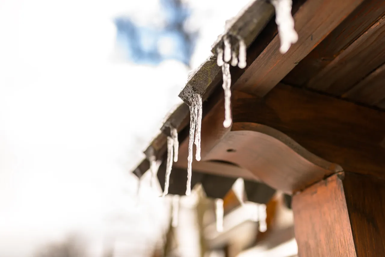 Ice dam and icicles forming along the edge of a roof in New York